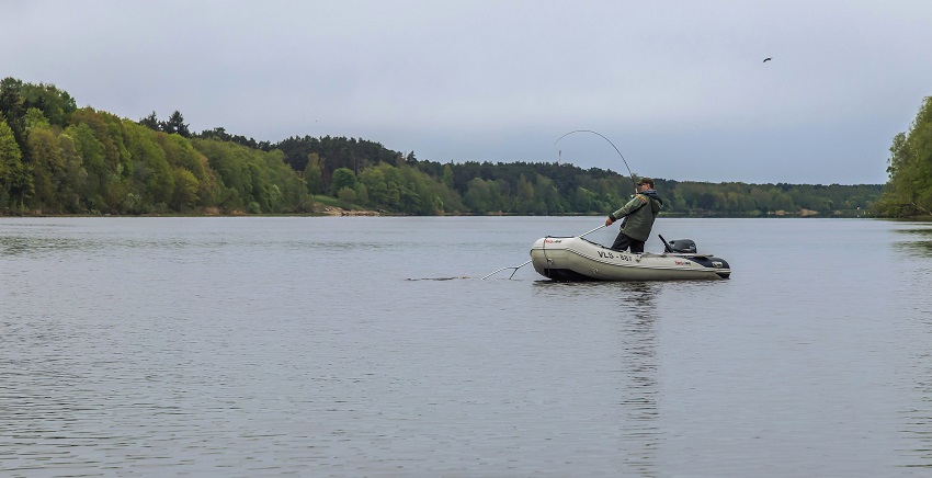 A fisherman on a lake with a boat